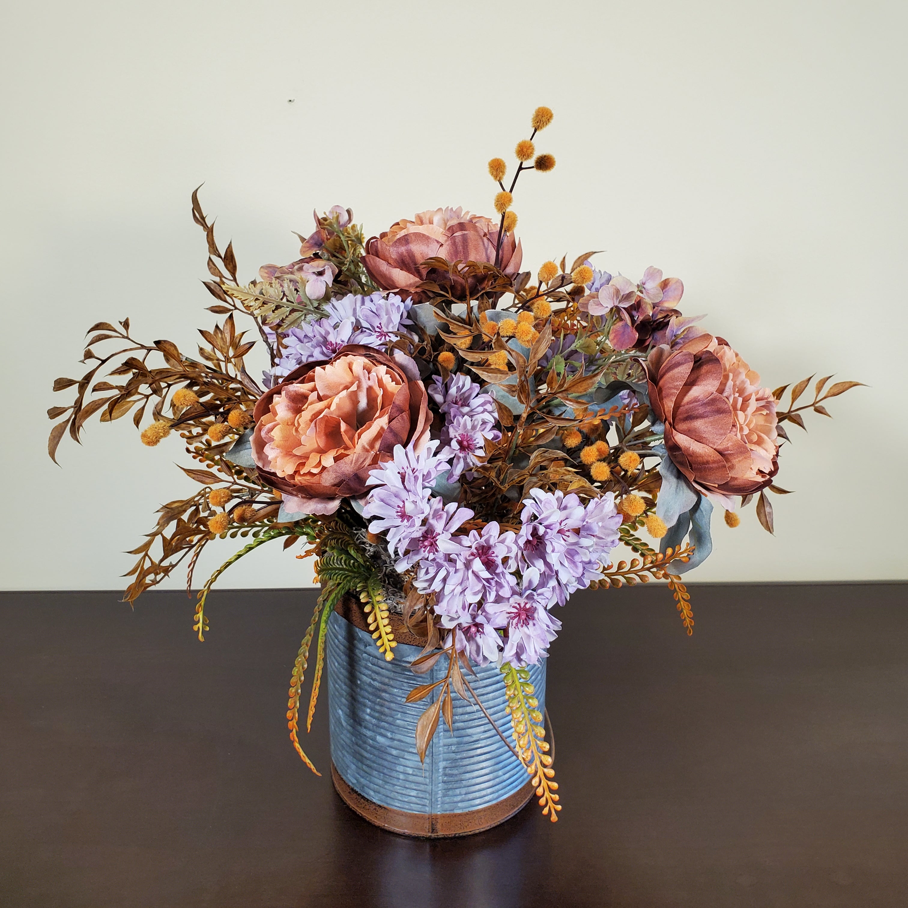 Fall Floral Arrangement with Peach Peonies, Lavender Mums, and Autumn Foliage in Textured Metal Container