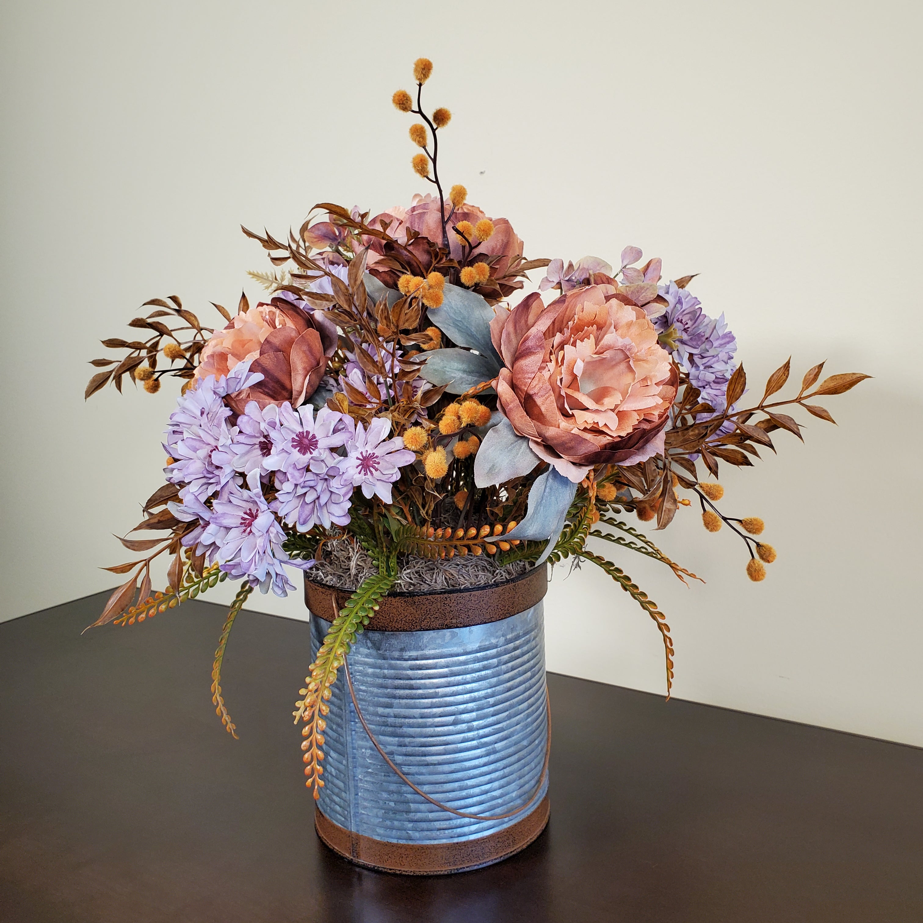 Fall Floral Arrangement with Peach Peonies, Lavender Mums, and Autumn Foliage in Textured Metal Container