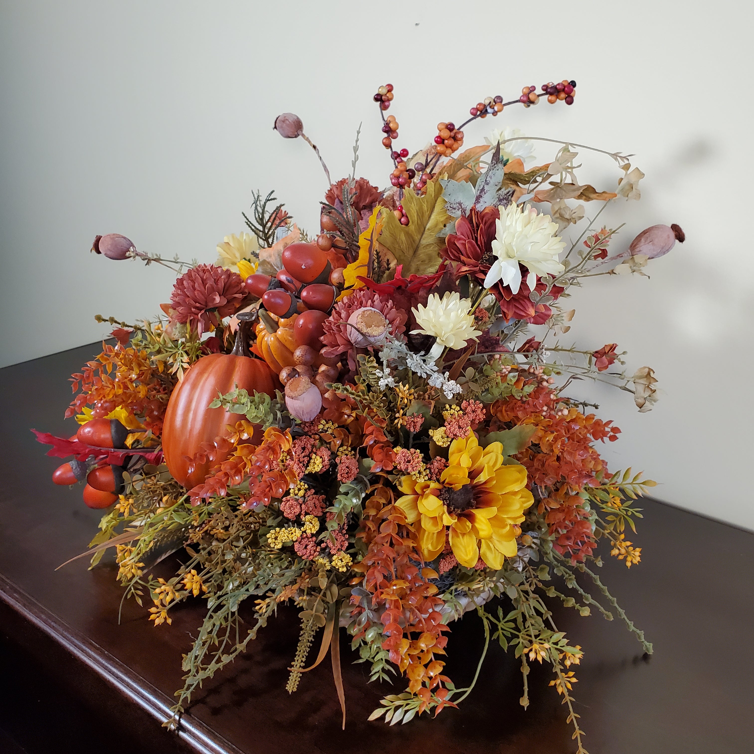 Fall Pumpkin Centerpiece with Autumn Leaves, Berries, and Seasonal Florals in Warm Harvest Colors