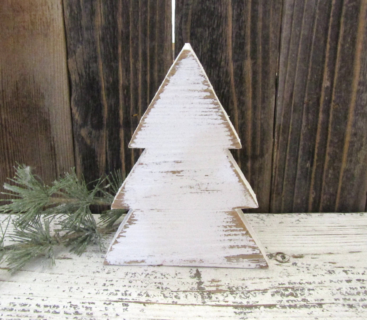 White distressed wood Christmas tree shelf sitter against weathered barn wood
