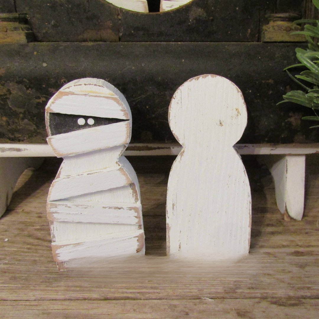 Small wood mummy front view with hand painted bandage wraps and black eye band beside a plain white painted back