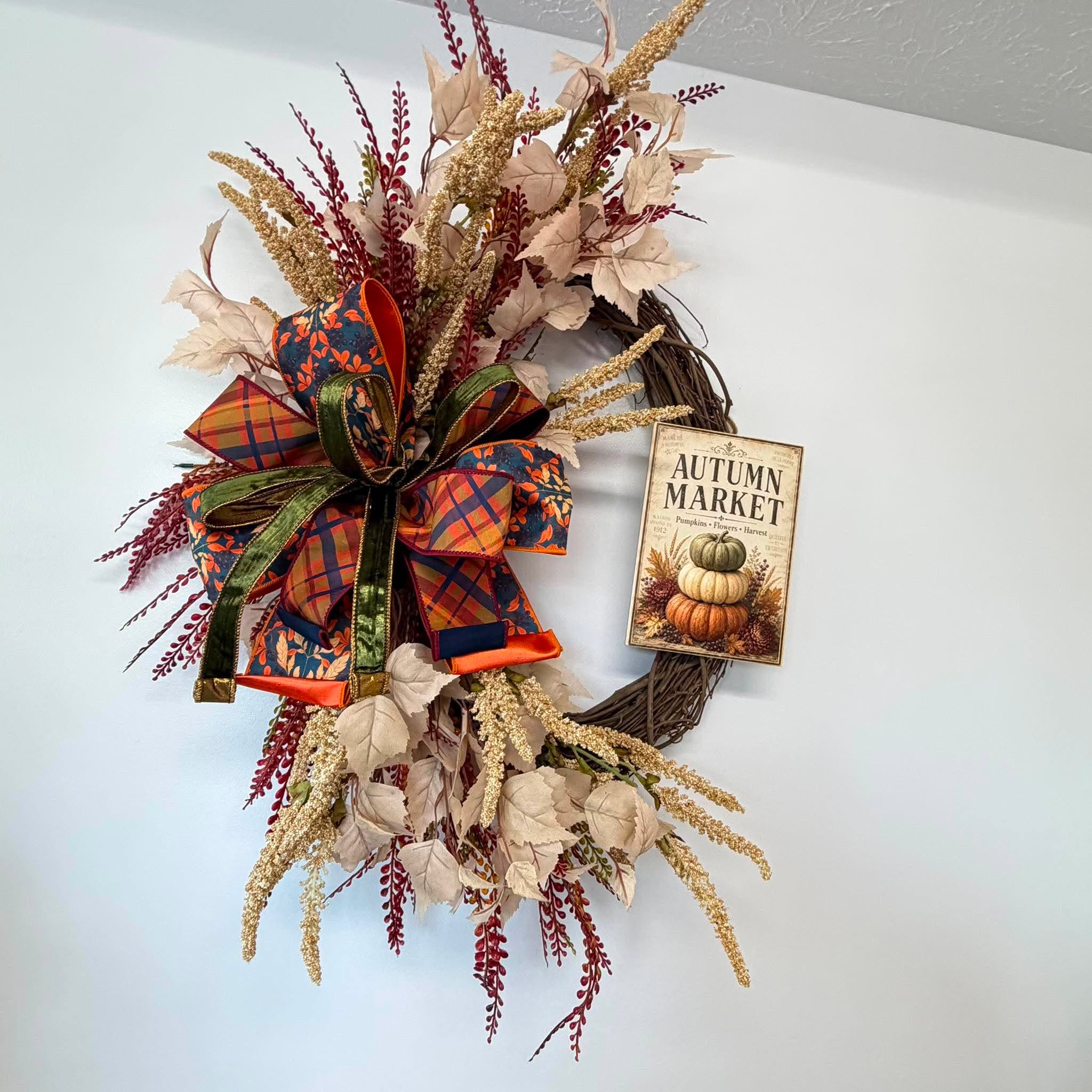 Cream silk leaves, gold amaranthus spikes and burgundy berry sprays filling one side of the fall wreath