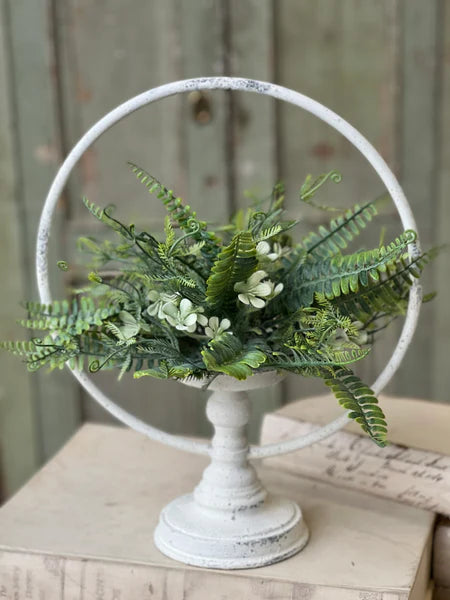 Decorative stand with green foliage against a wooden background