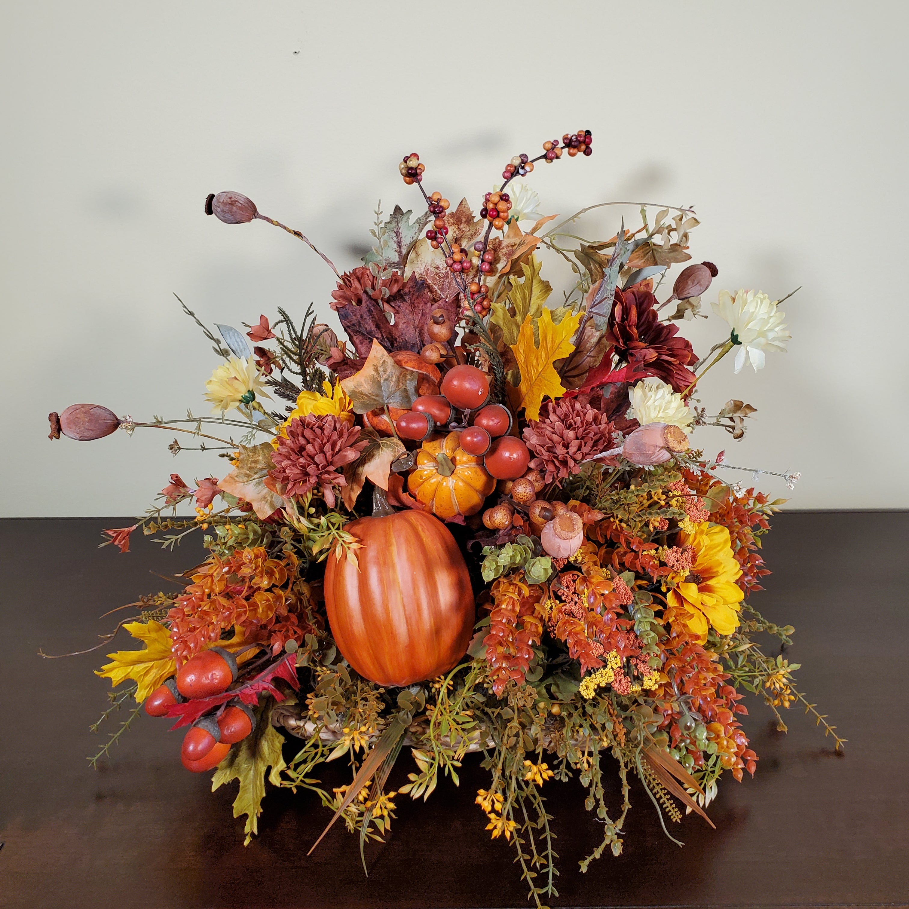 Fall Pumpkin Centerpiece with Autumn Leaves, Berries, and Seasonal Florals in Warm Harvest Colors