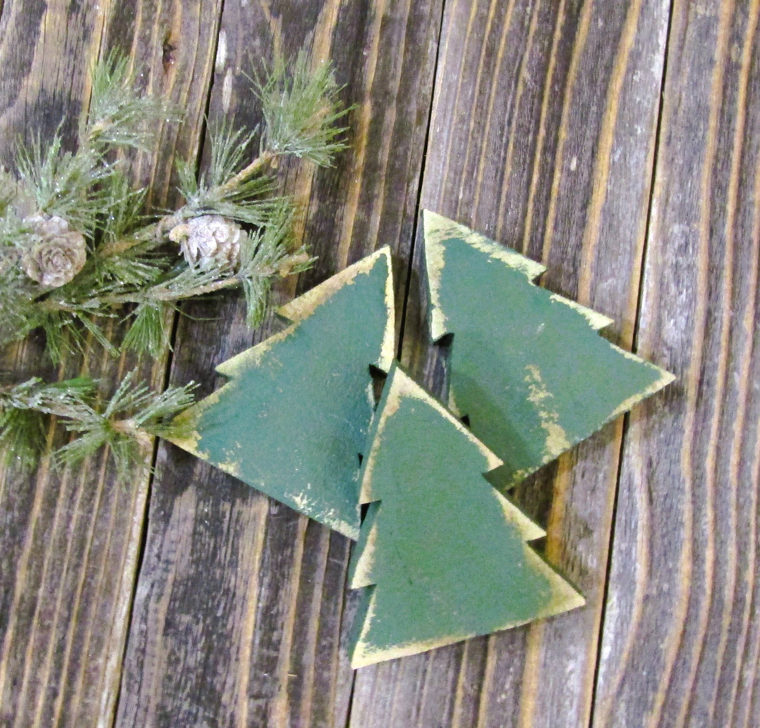 Green distressed wood Christmas tree bowl fillers arranged on weathered barn wood with pine
