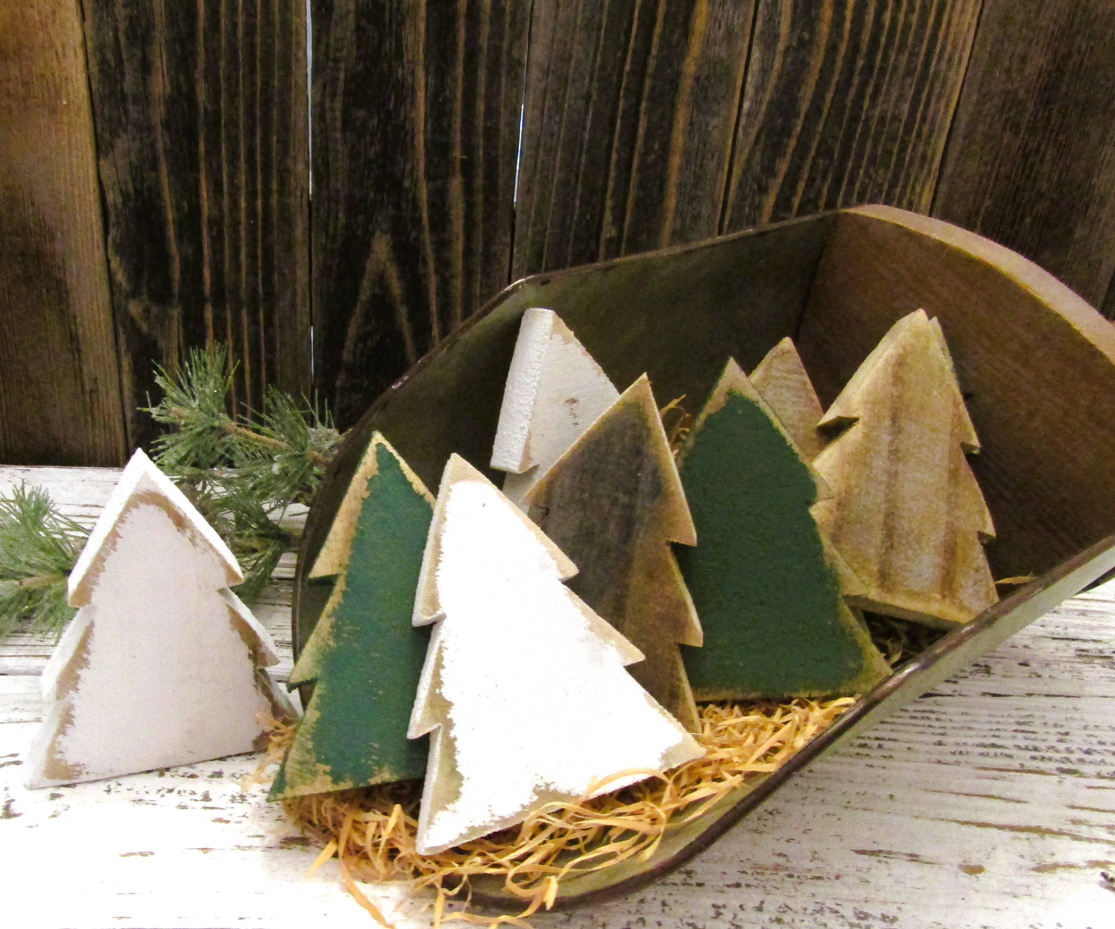 White, green and natural wood Christmas tree bowl fillers in a wooden dough bowl with raffia