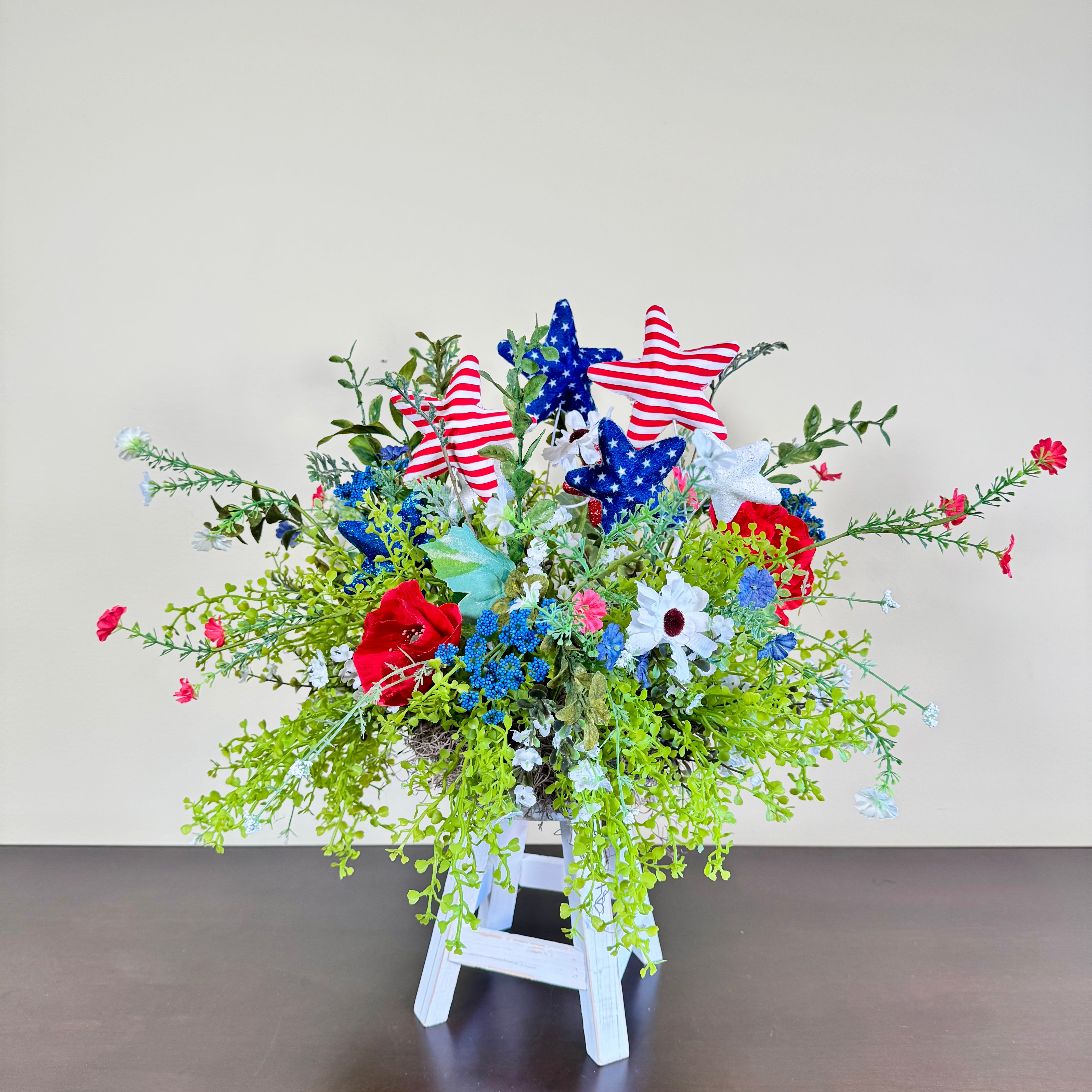 Patriotic Floral Arrangement with Red White Blue Stars on White Wood Stand