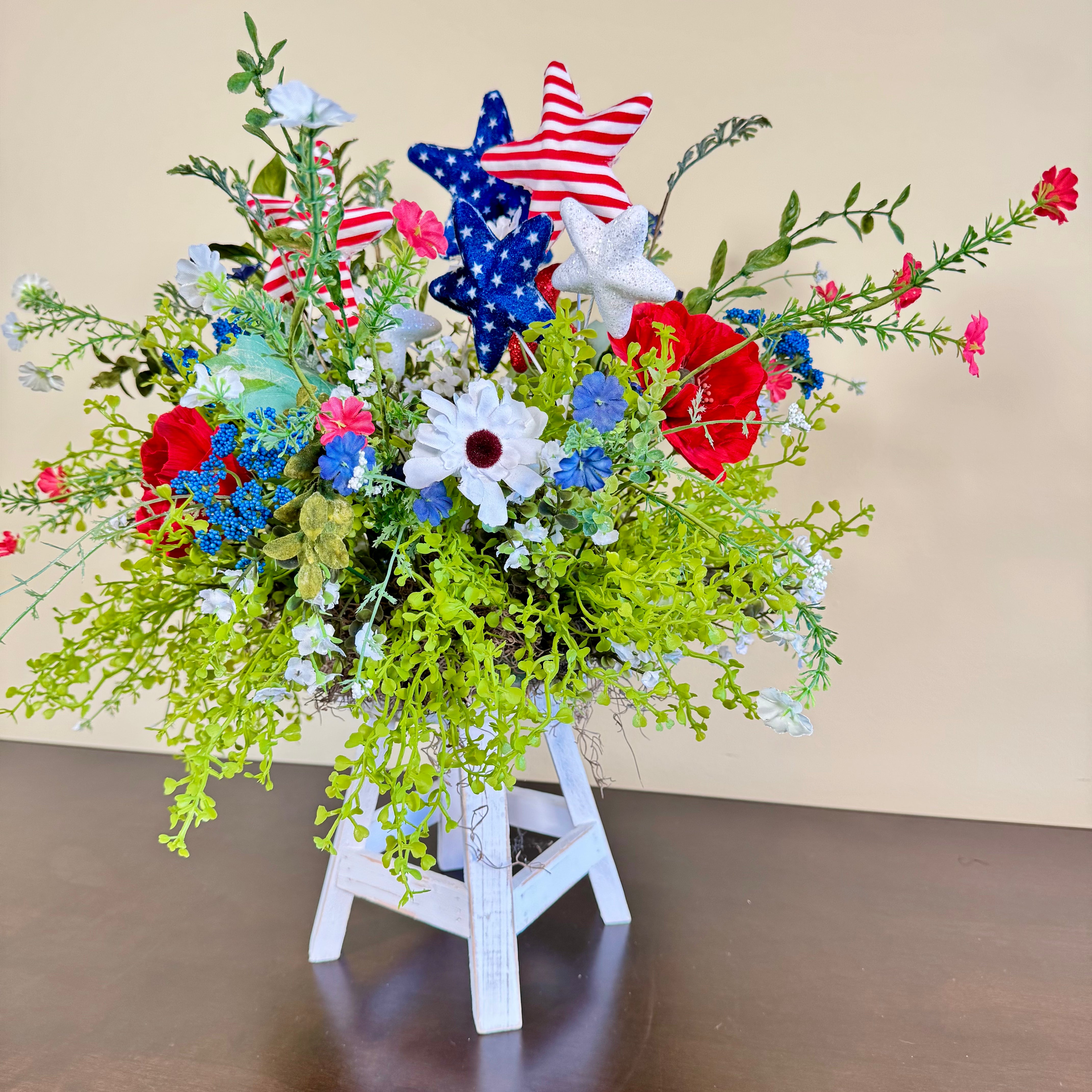 Patriotic Floral Arrangement with Red White Blue Stars on White Wood Stand