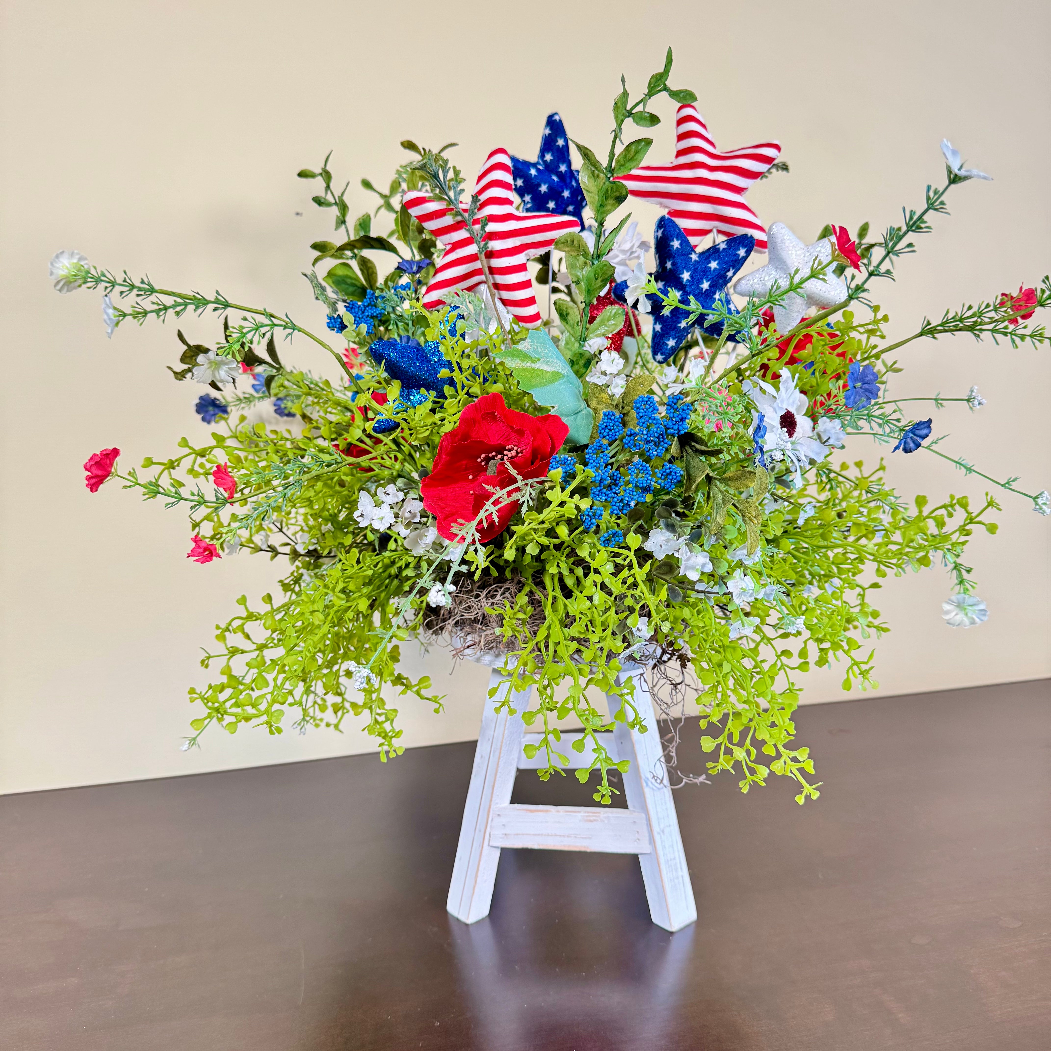 Patriotic Floral Arrangement with Red White Blue Stars on White Wood Stand