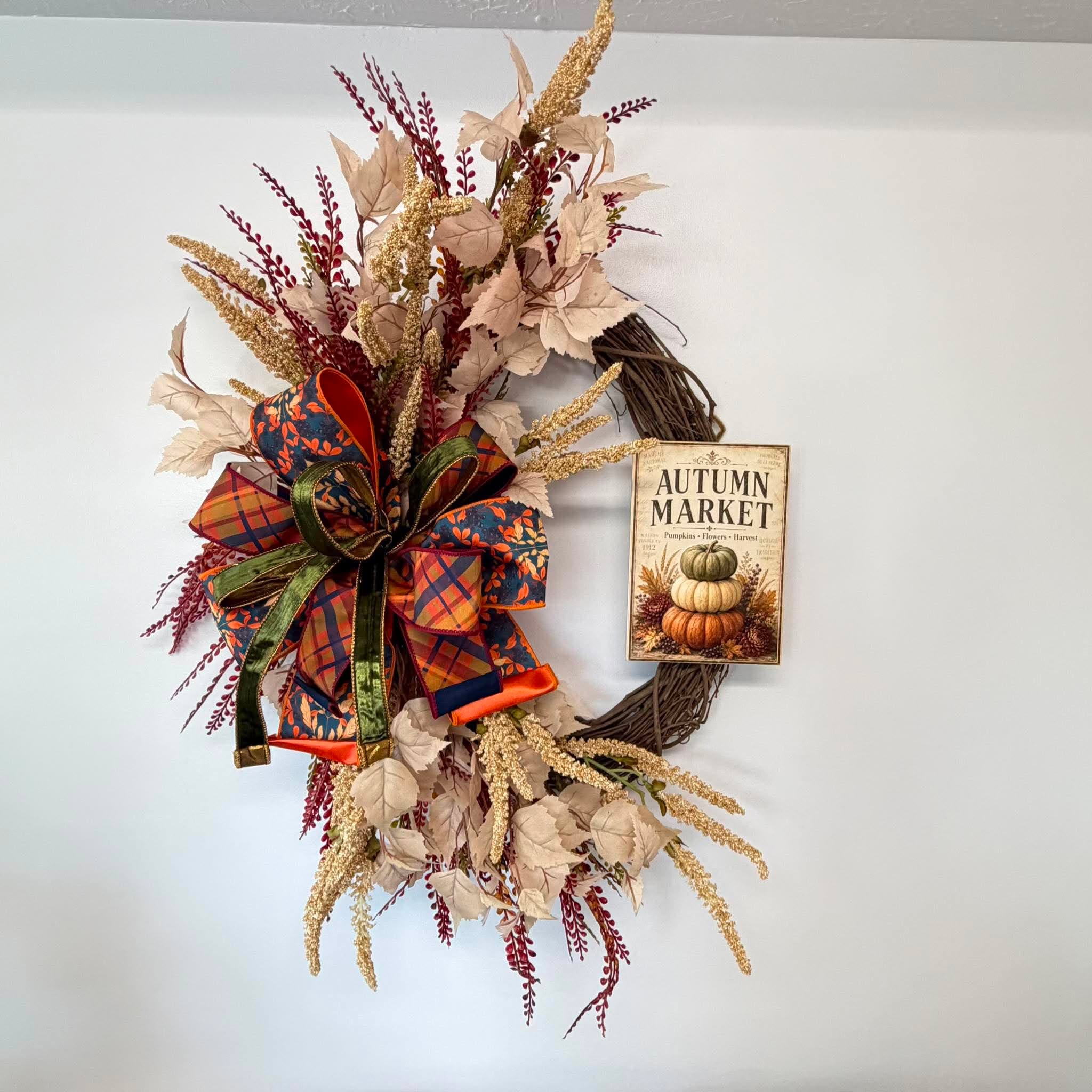 Autumn Market fall grapevine wreath with cream leaves, gold amaranthus and a plaid bow, shown at an angle