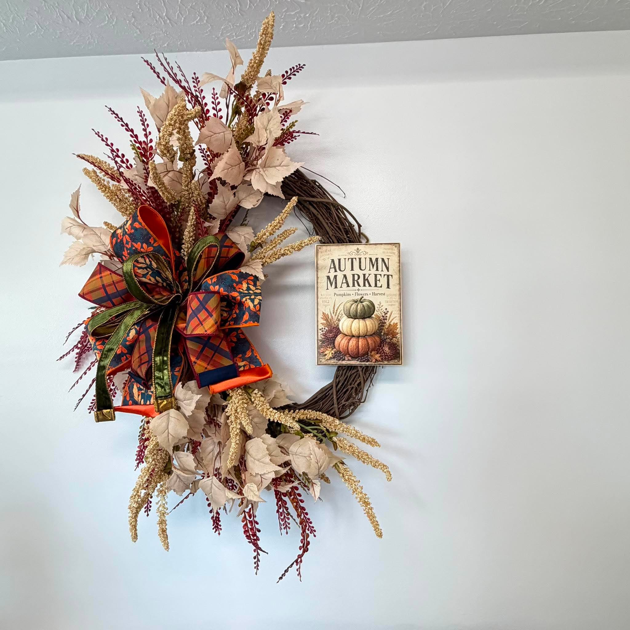 Autumn Market pumpkin sign fall wreath hanging on a wall as entryway and front door decor