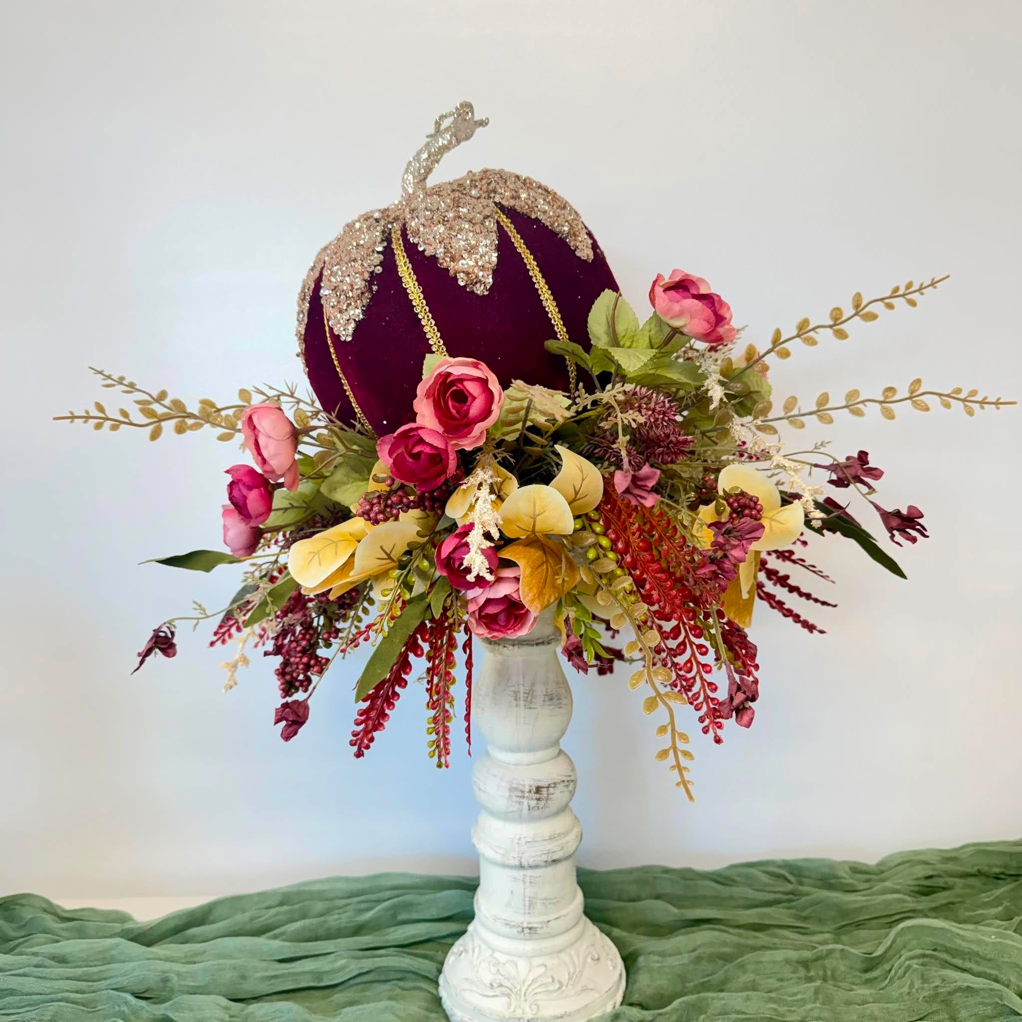 Burgundy velvet pumpkin fall arrangement styled as a table centerpiece on a white pedestal