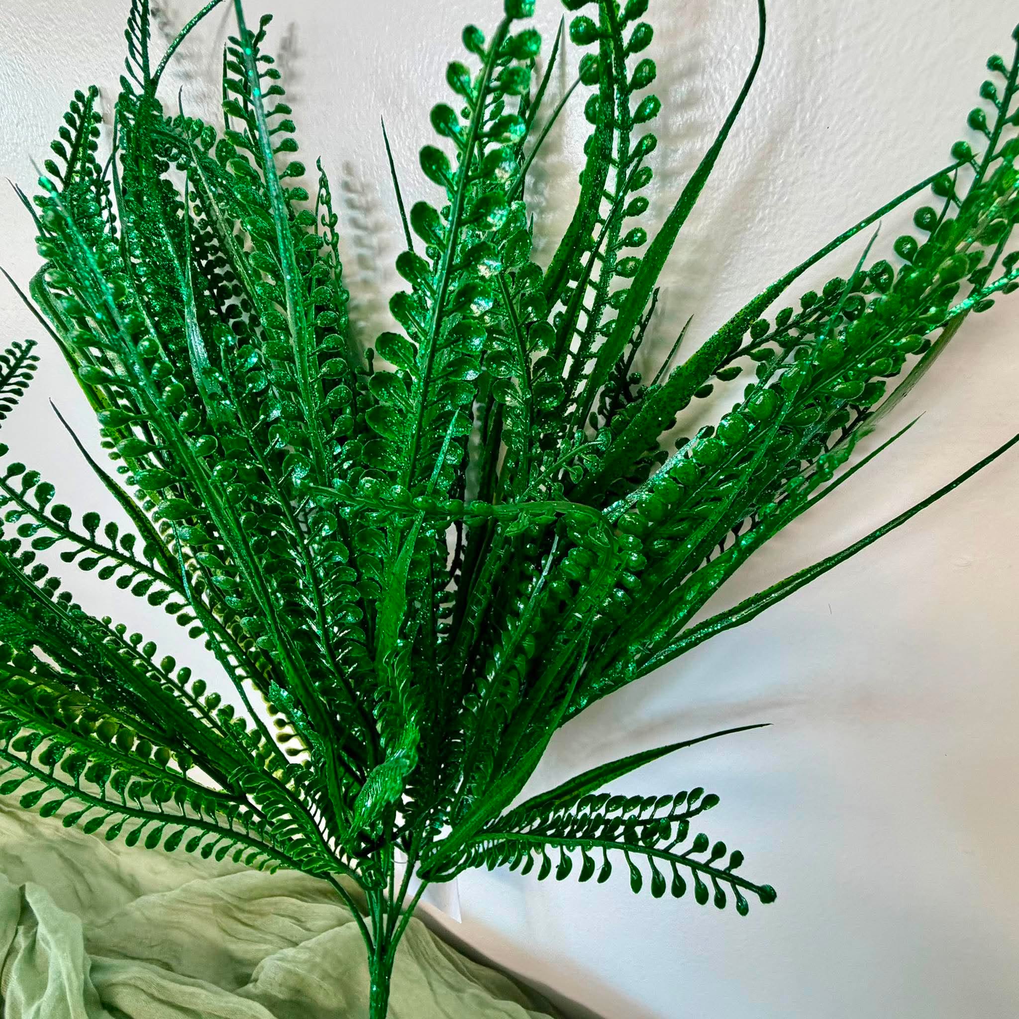 Close Up of Glossy Green Fern Fronds and Bead Grass on Artificial Bush