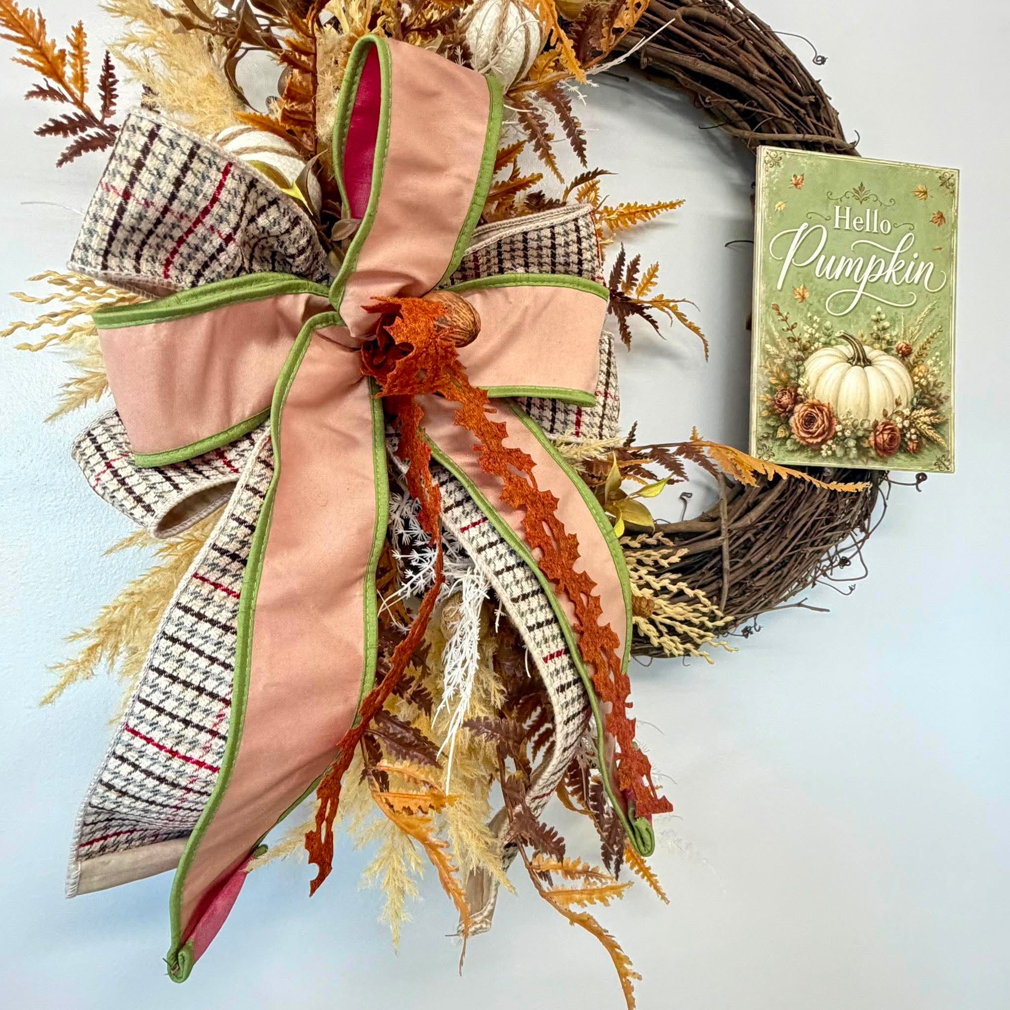 Close-up of the blush peach velvet and houndstooth plaid bow with a natural walnut center