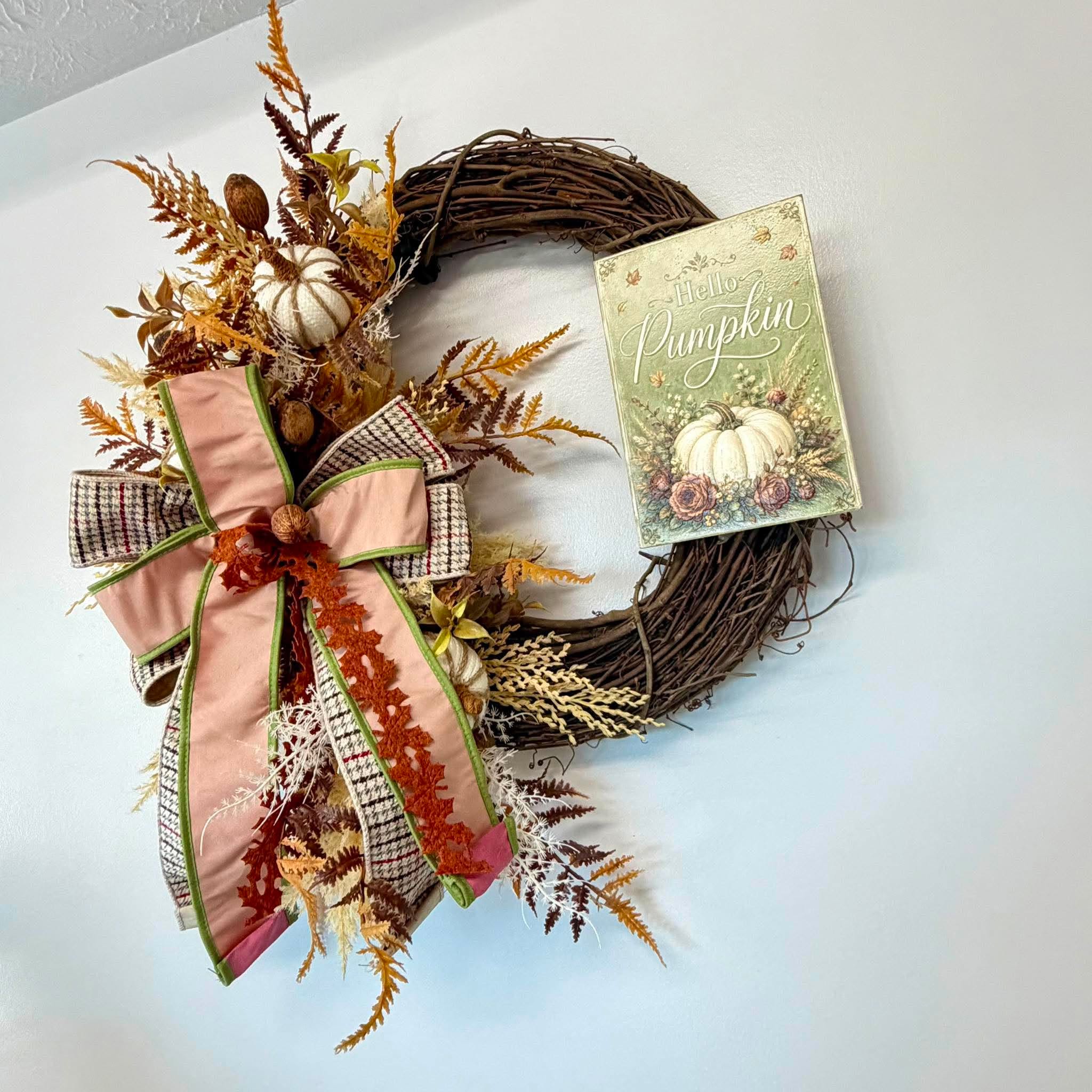 Ivory knit sweater pumpkin tucked among dried rust and gold ferns on the grapevine wreath