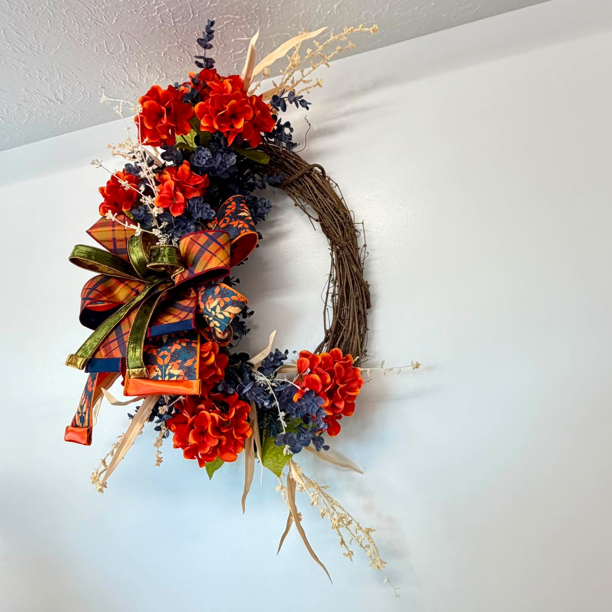 Detail of navy blue berry clusters and burnt orange hydrangea blooms with dried cream grasses